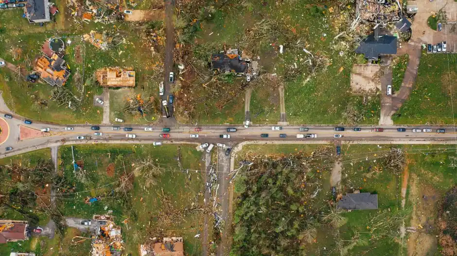 Aerial view of village houses ruined by wild storm near windthrown trees and electricity lines