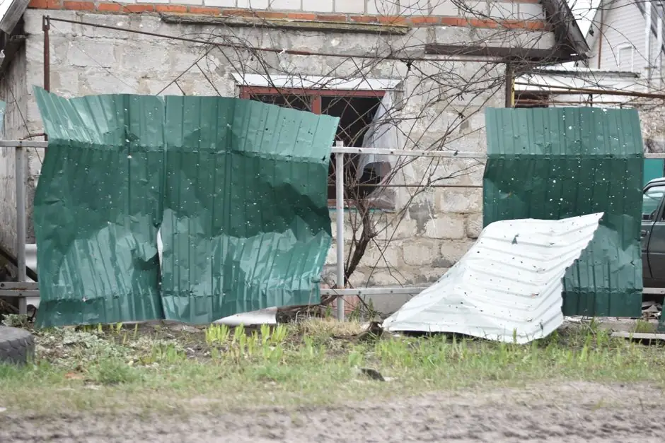 Old house with a damaged and rusted metal fence. Signs of neglect and decay in an outdoor setting.